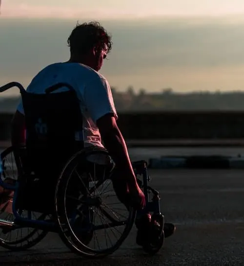 man in electric wheelchair watching sun set