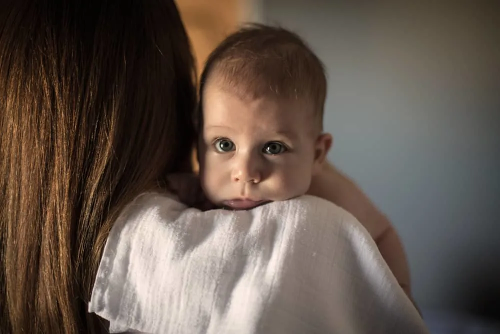 mom holding baby on shoulder to burp