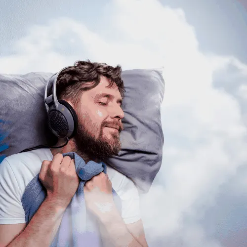 Man with headphones, sound asleep, sleeping in clouds