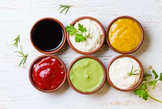 Sauces ketchup, mustar, mayonnaise, wasabi, soy sauce in clay bowls on wooden white background