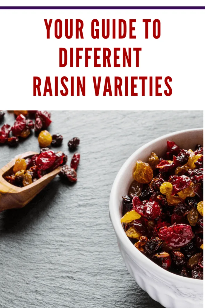 Mixed raisin varieties in a wooden scoop and bowl, highlighting their diverse colors and textures.