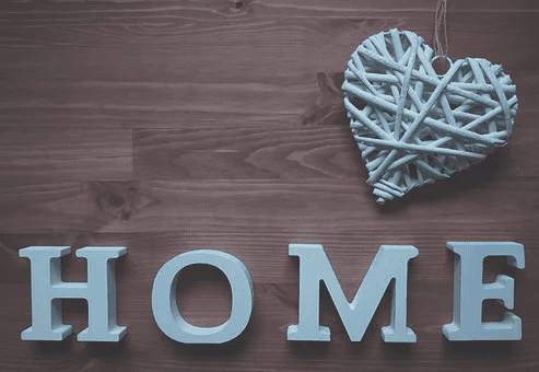 Letters HOME on wood with string heart above