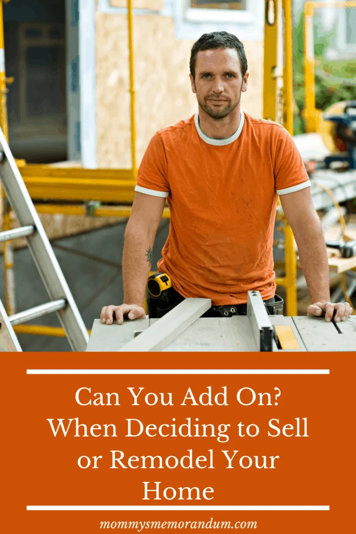 man in orange shirt working with blue prints for home remodel