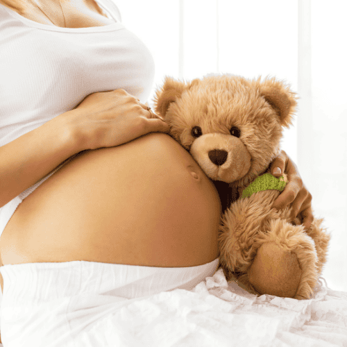 Pregnant woman holding teddy bear