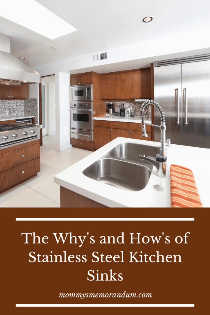 stainless steel kitchen sink on island in kitchen with peach towel resting on counter nearby