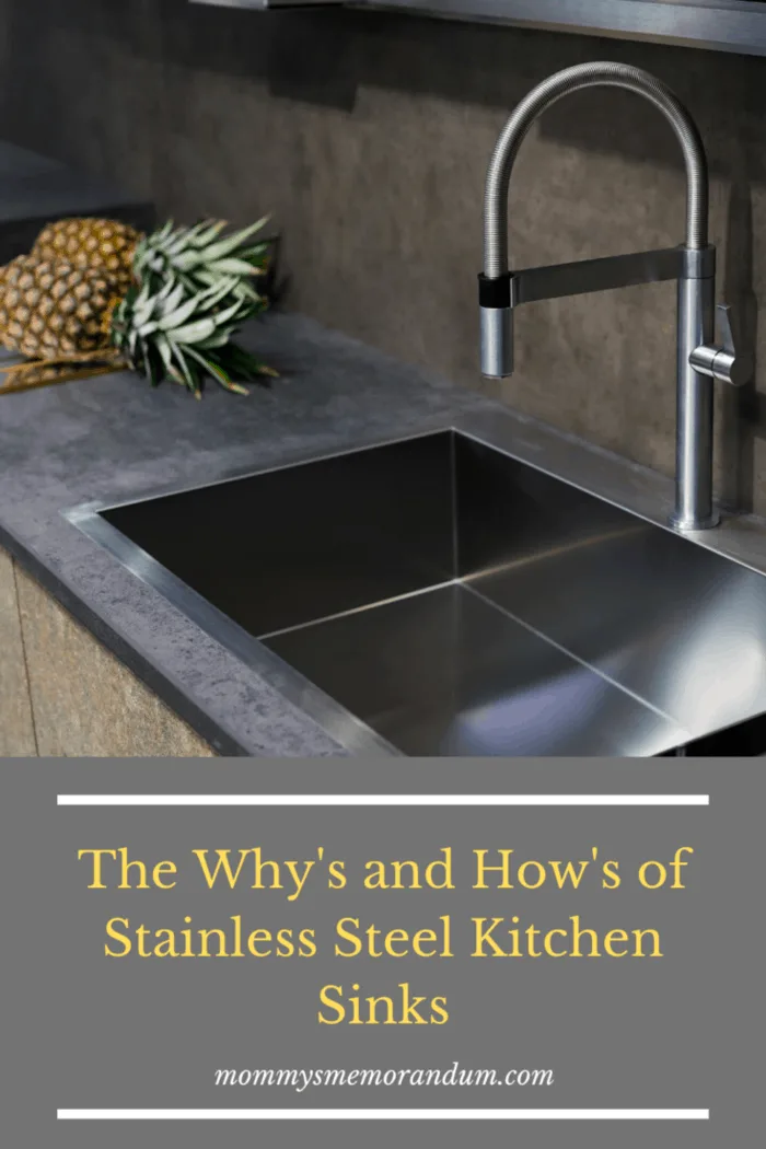 stainless steel kitchen sink in shadows with two pineapples next to sink