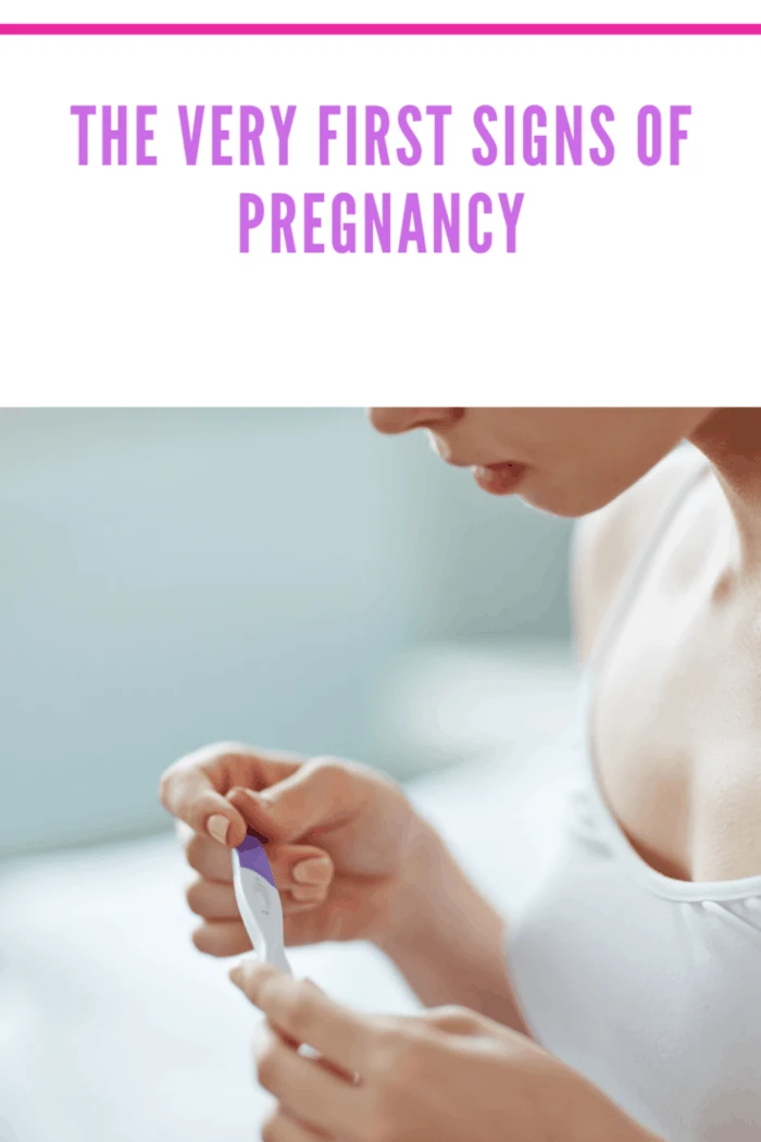 woman with early signs of pregnancy holding pregnancy test