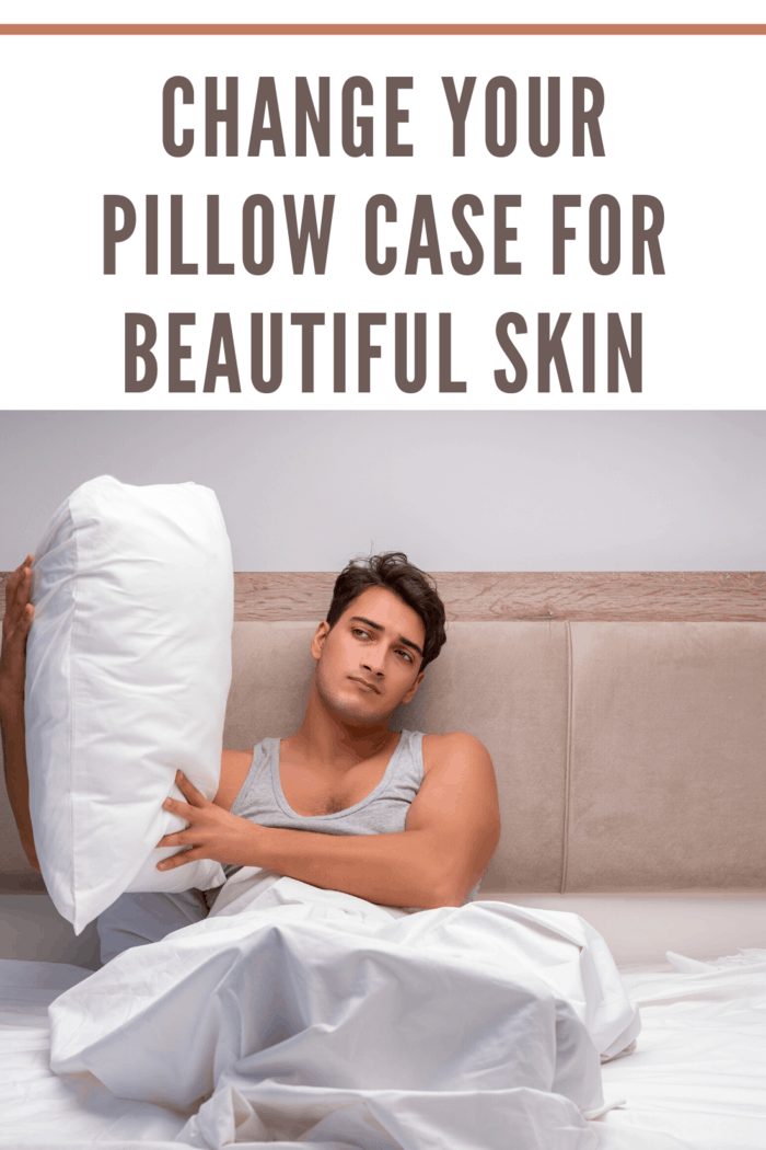 man in bed holding pillow