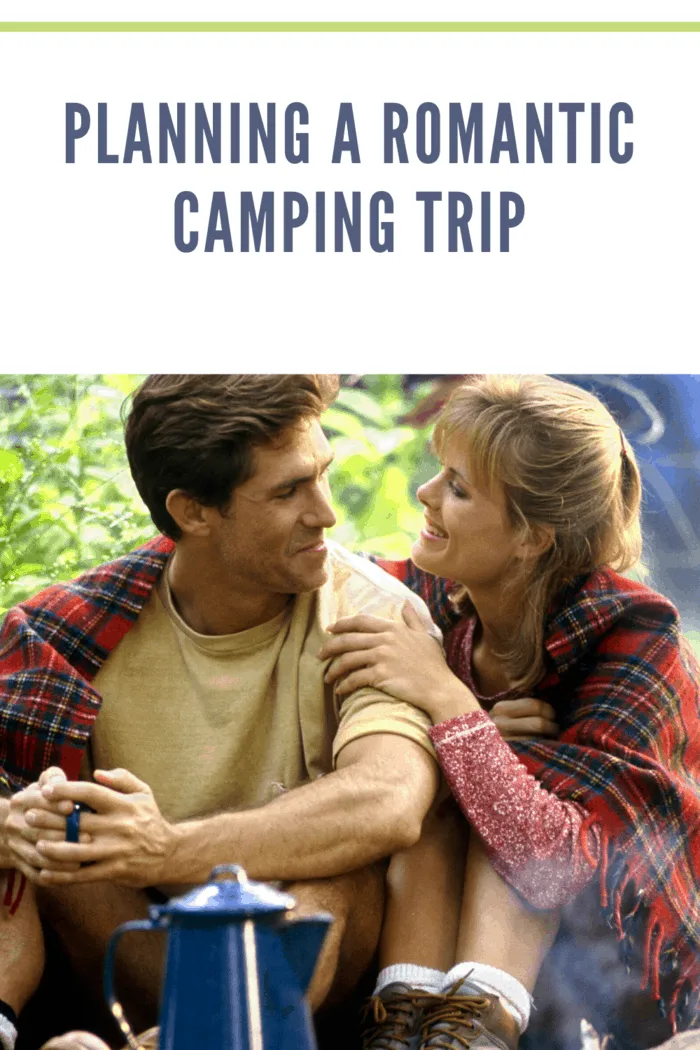 couple camping and sitting with blanket