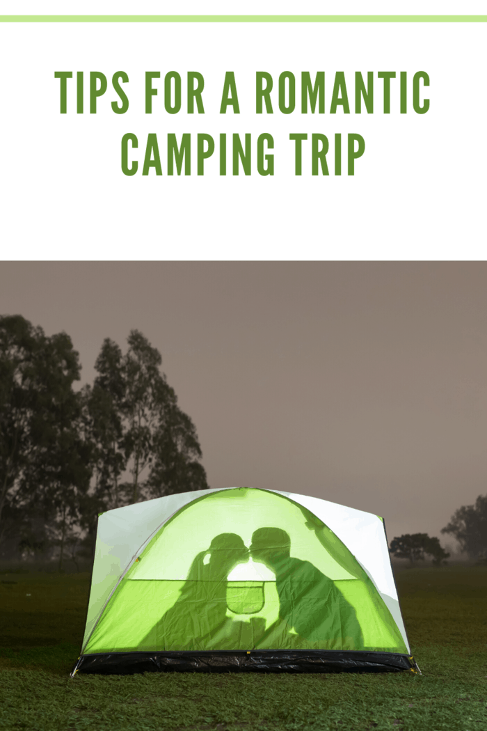 couple camping with inside of tent illuminated