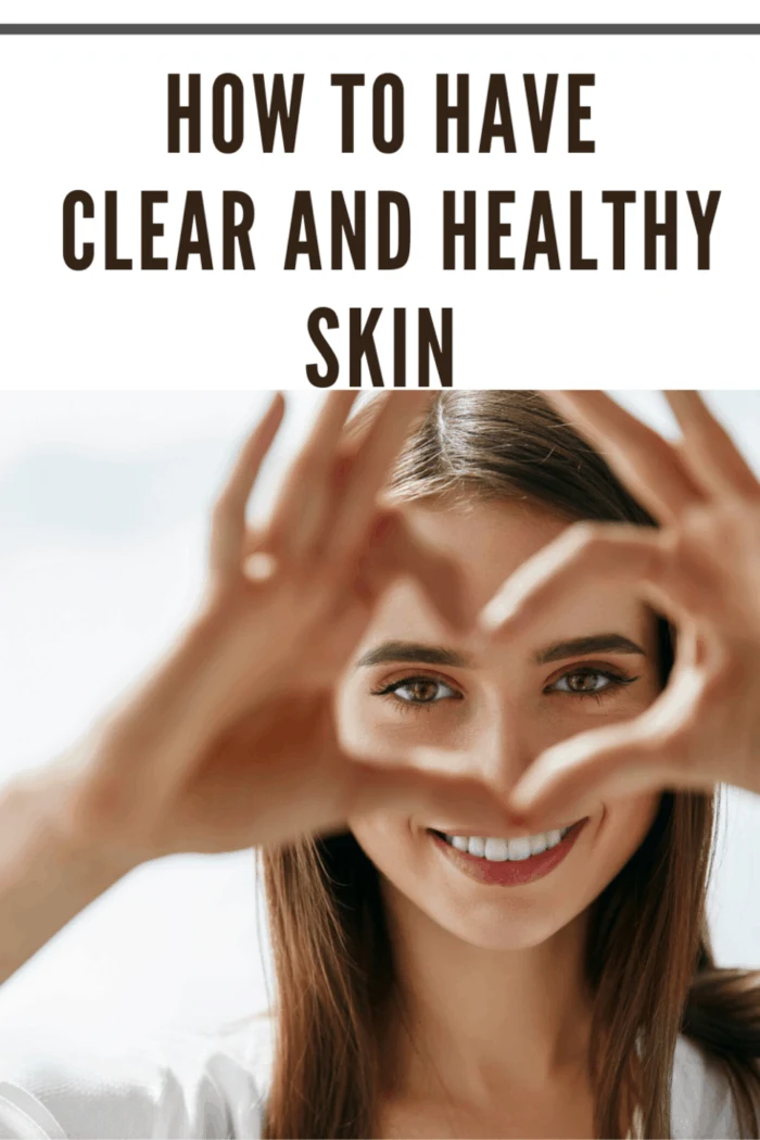 woman with clear and healthy skin making heart with fingers