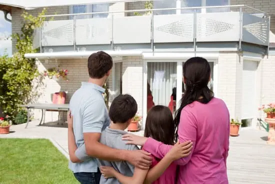 Young family standing in front of their dream home