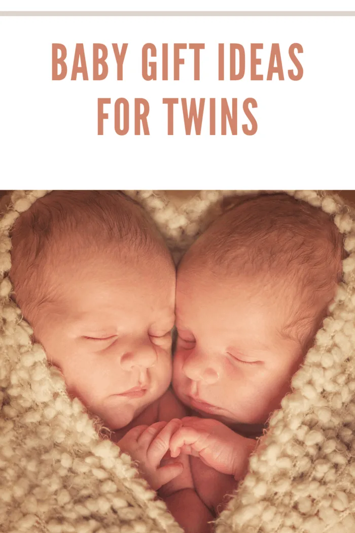 twin baby wrapped in beige blanket. The blanket is postitioned as a heart with only their faces in the heart.
