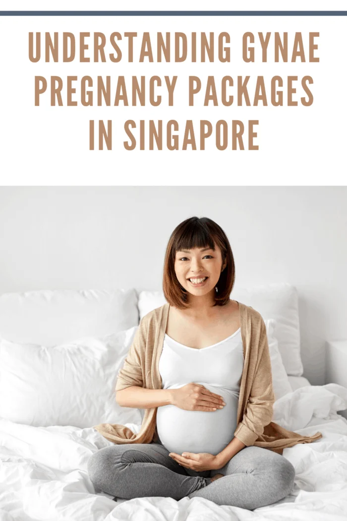 happy pregnant woman sitting on bed holding belly