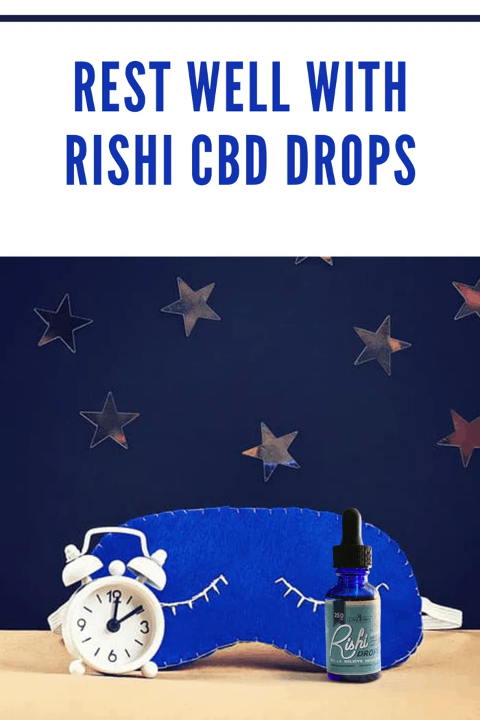 Live Rishi CBD drops nxt to alarm clock and sleep mask with dark blue background with gold stars.