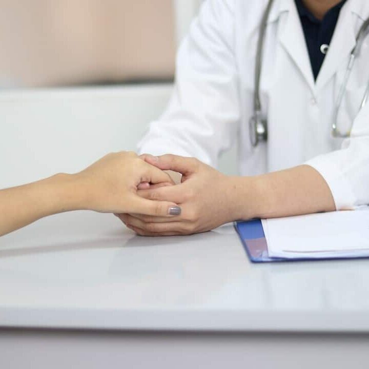 family physician holding patient's hand