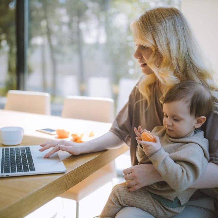 single mother holding toddler while looking on laptop finding true love