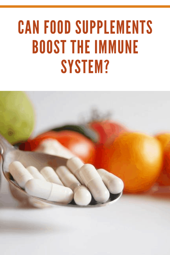 tomatoes in background with supplements on a spoon represented if food supplements can boost the immune system.