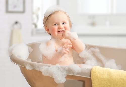 toddler taking a bubble bath on counter