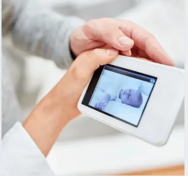 Parents look at a baby monitor with camera for video surveillance of babies