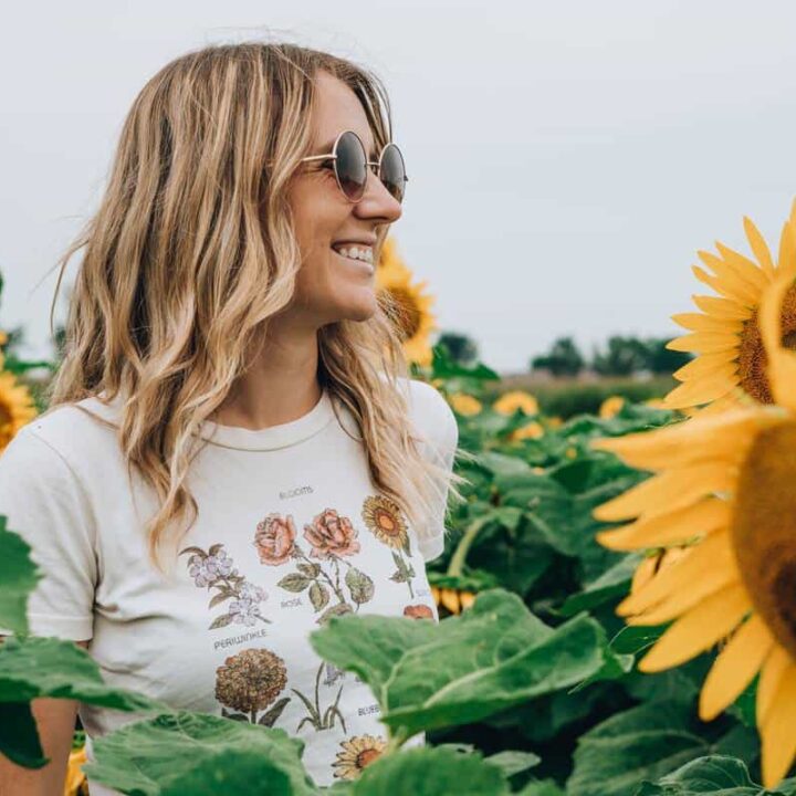 woman with glasses in sunflower fieild