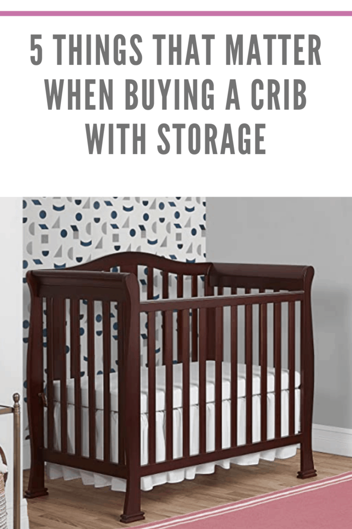 brown crib with storage in nursery with pink rug