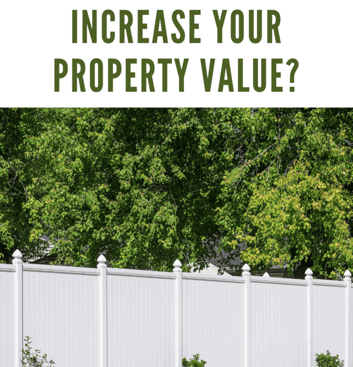 White vinyl fence running across a homeowners back yard.