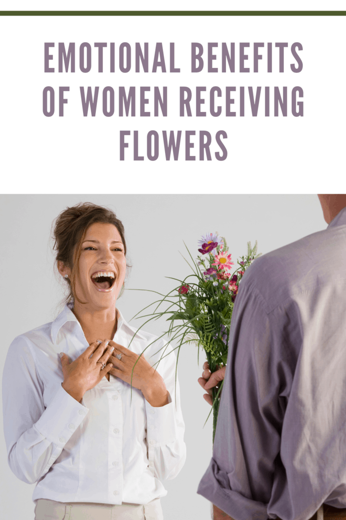 Woman smiles receiving flowers from man in lavender shirt