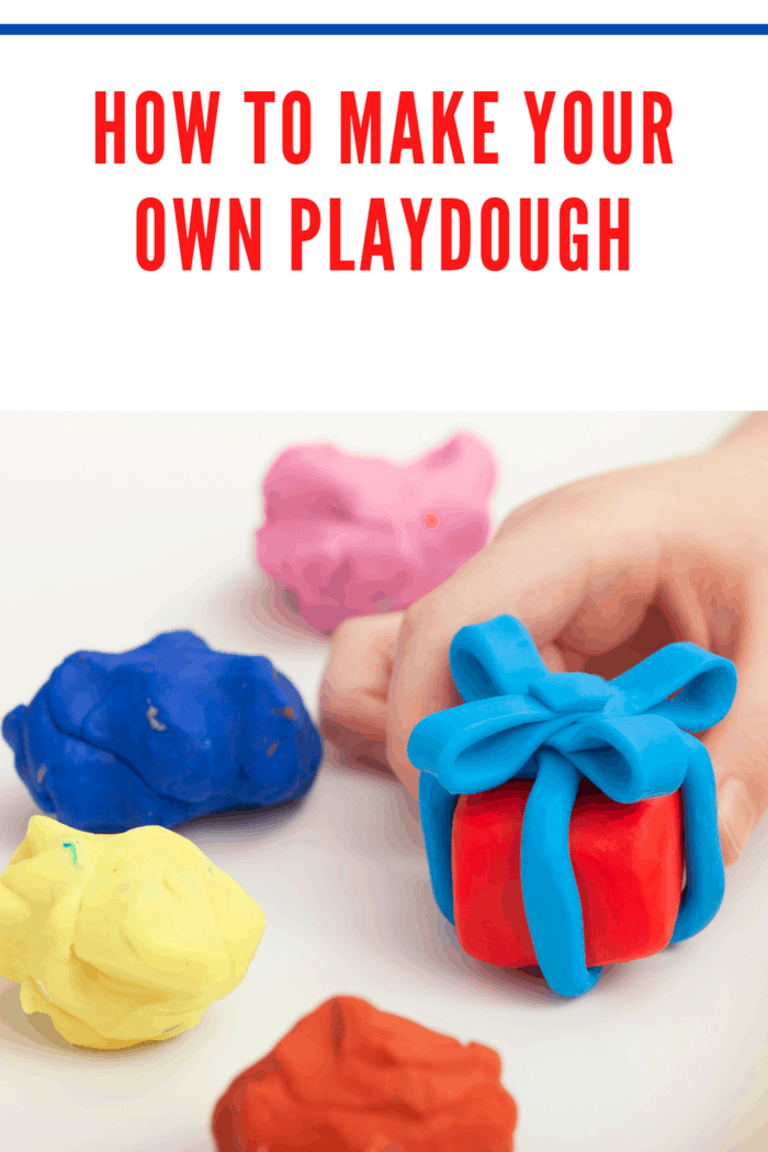 Child playing with playdough and making a giftbox. Close up.