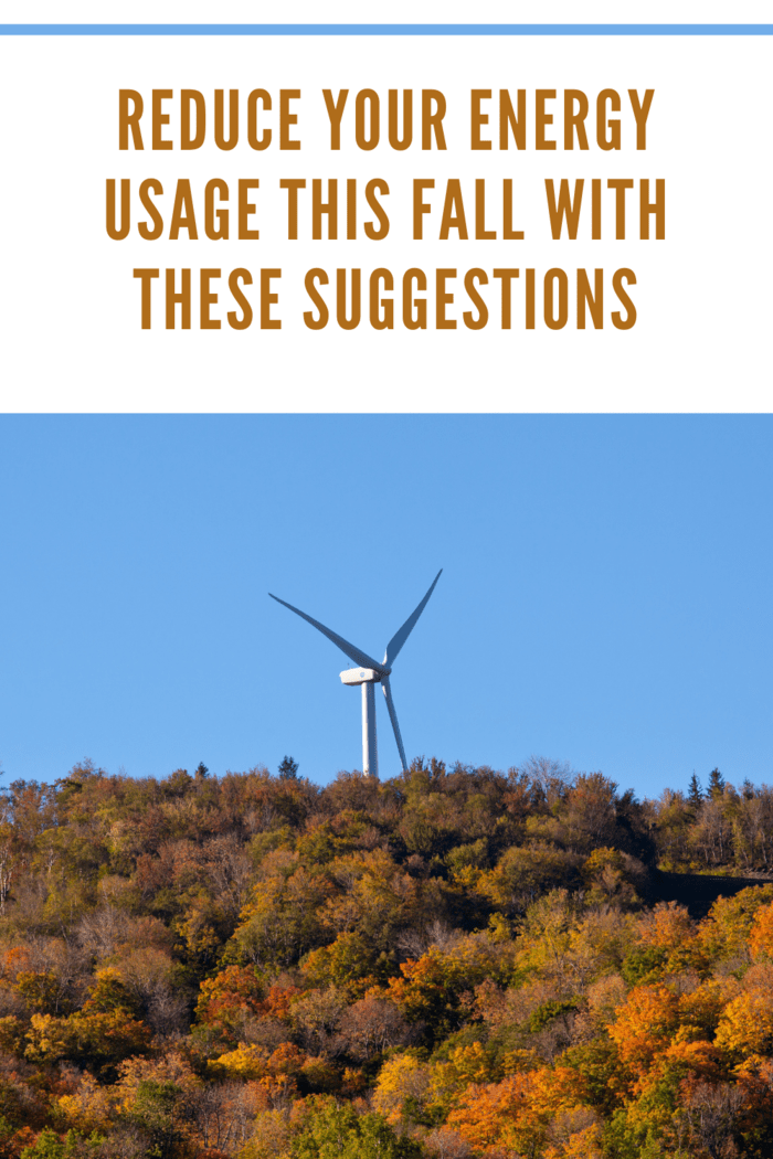 Large wind generator on hilltop above autumn trees to reduce energy usage