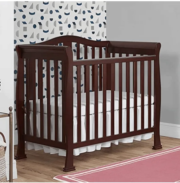 brown crib with storage in nursery with pink rug