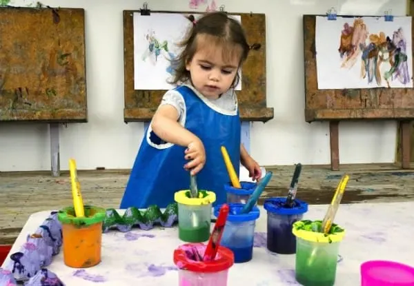 Adorable little girl painting and drawing as one of the best teaching practices for early childhood education