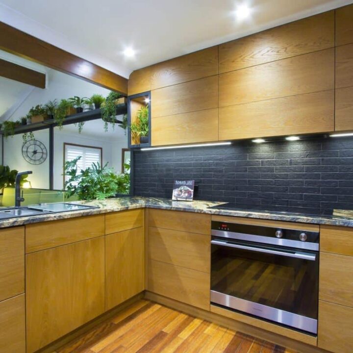 urban kitchen with oak cabinets and black backsplash