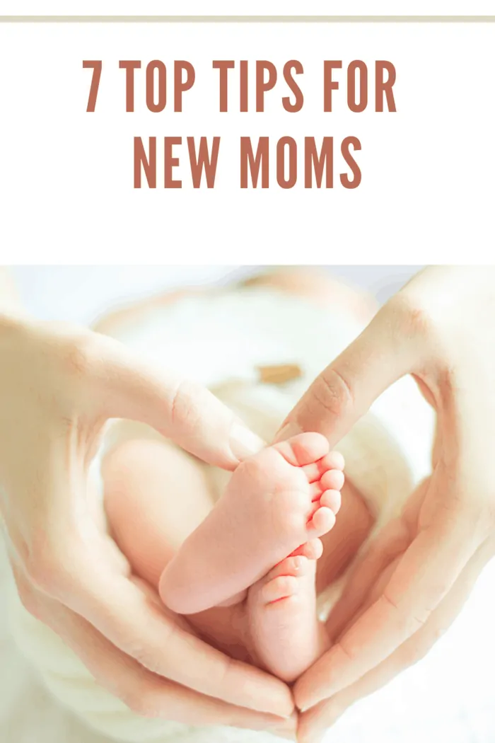 Litle baby feet in mom'e hands, little babies crossed legs in moms hands with white background