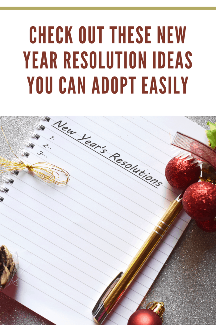 new year's resolutions written on paper in notebook with red glitter balls