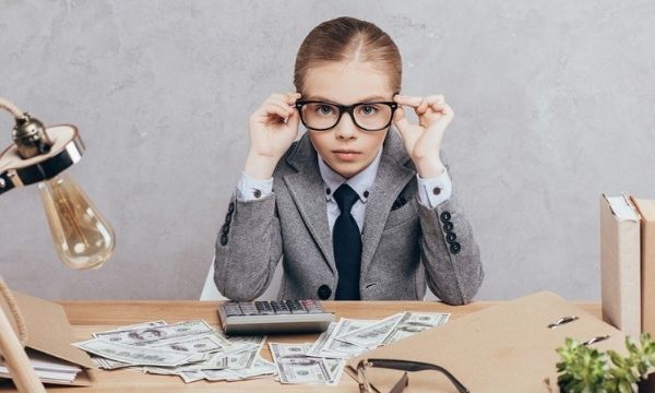 child dressed as businessperson learning the value of money