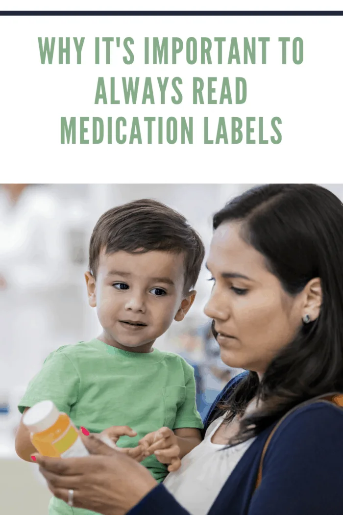 Mid adult woman reads medication dosage instructions on prescription medication. She is holding her toddler son.