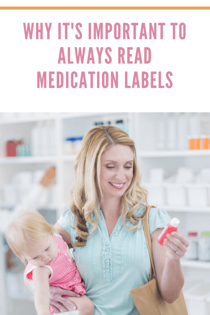 Mid adult Caucasian woman is mother shopping for cold medicine while holding her toddler daughter in local pharmacy. Mother is reading medication label while holding baby.