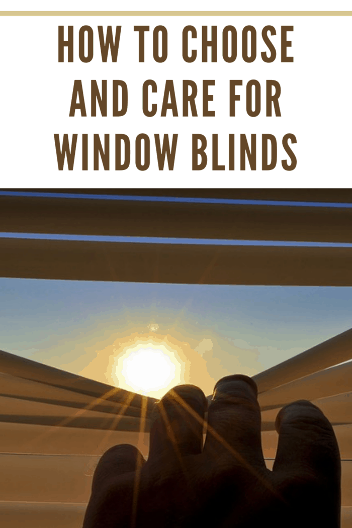 hand pulling down blinds to have bright sun beam through