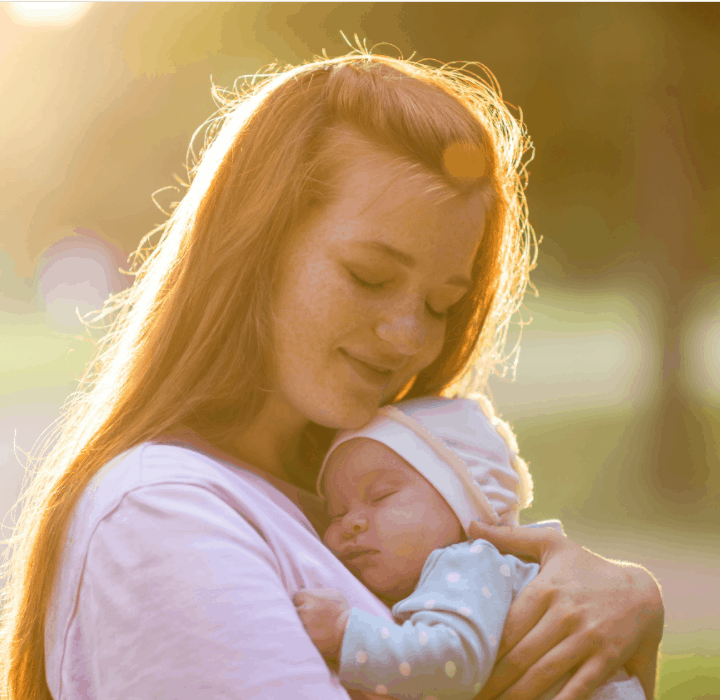 A young mother with a small newborn in her arms in a summer park. Happiness Maternity, Recovery Postpartum Concept