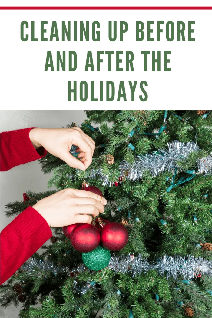 Female hands gathering red and green ornaments to be put into storage with Christmas tree in background