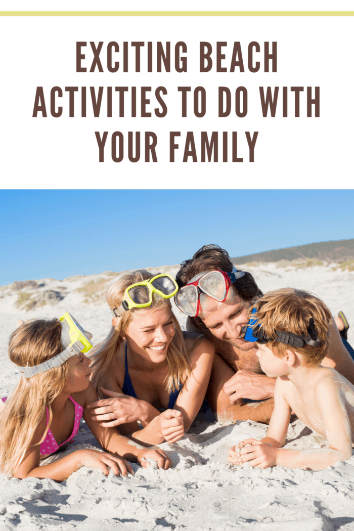 Family lying on front on sand wearing snorkeling mask. Happy family on beach with snorkels having fun. Family ready for snorkeling at beach.