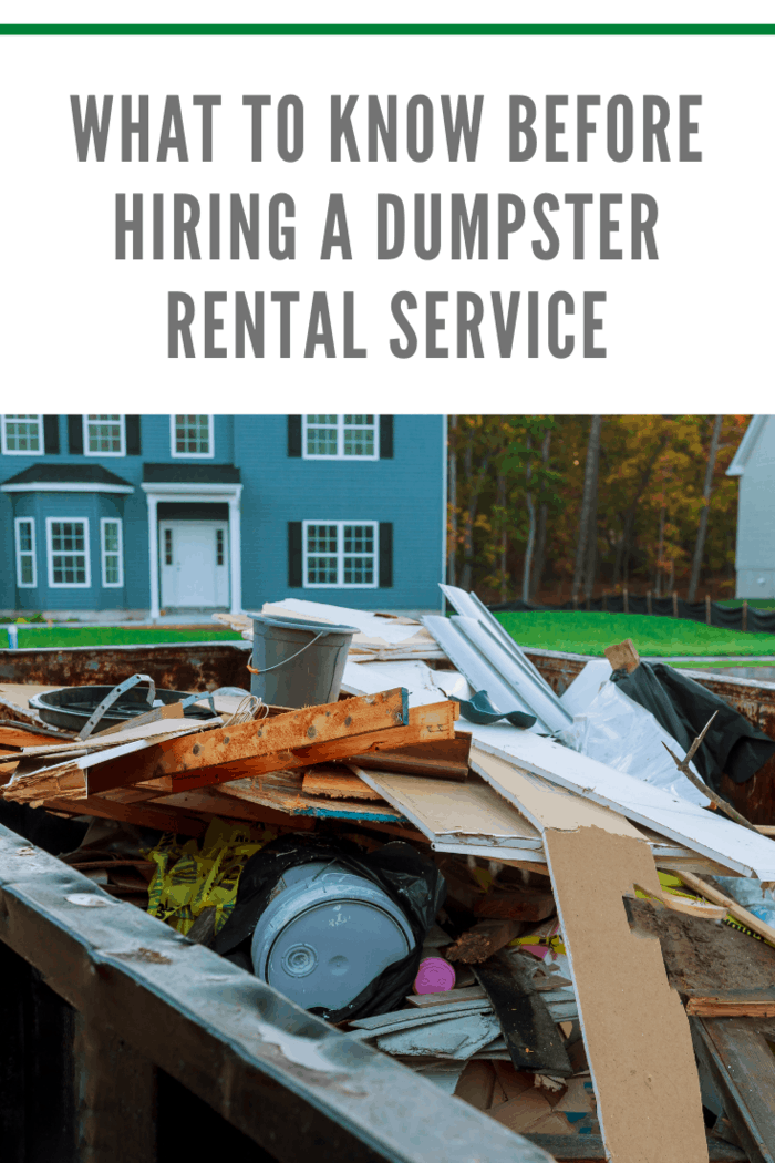 dumpster rental filled with debri in front of two story home