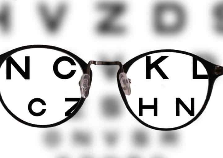 myopia correction glasses on the eye chart letters background