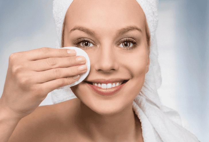 Close up of happy woman removing make- up