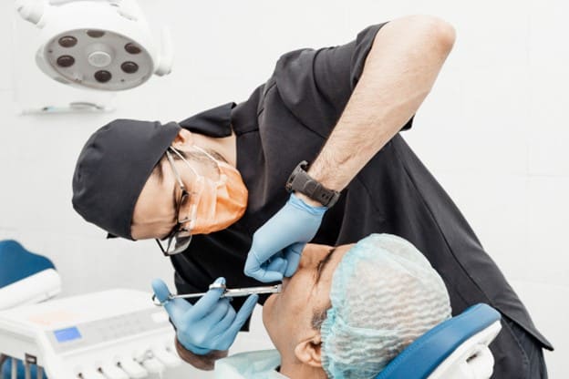 dentist performing teeth extraction on patient