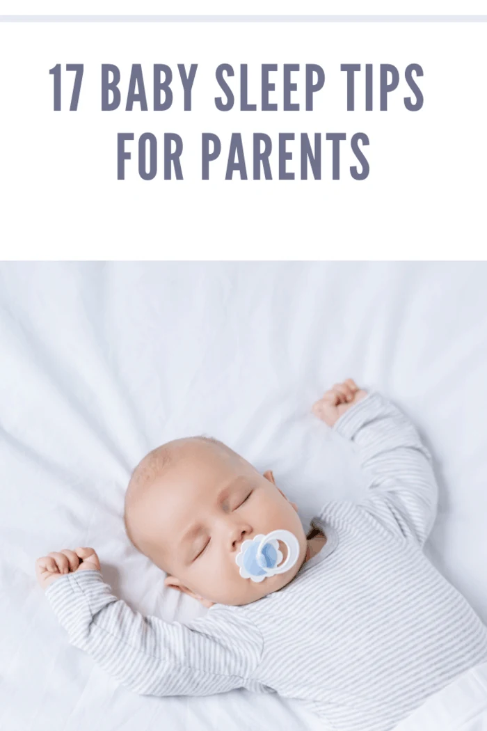 overhead view of baby with pacifier in mouth sleeping on bed