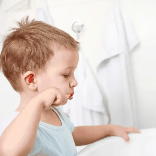 toddler practicing dental care tips by brushing his teeth
