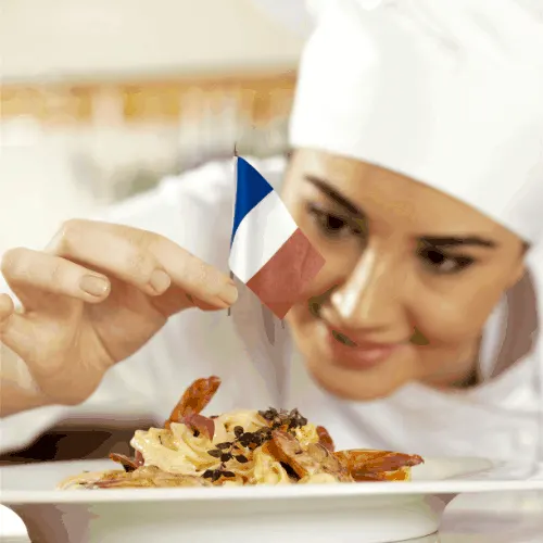 French chef putting France flag on a dish.