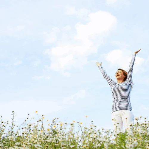Woman with stretched arms in flower field